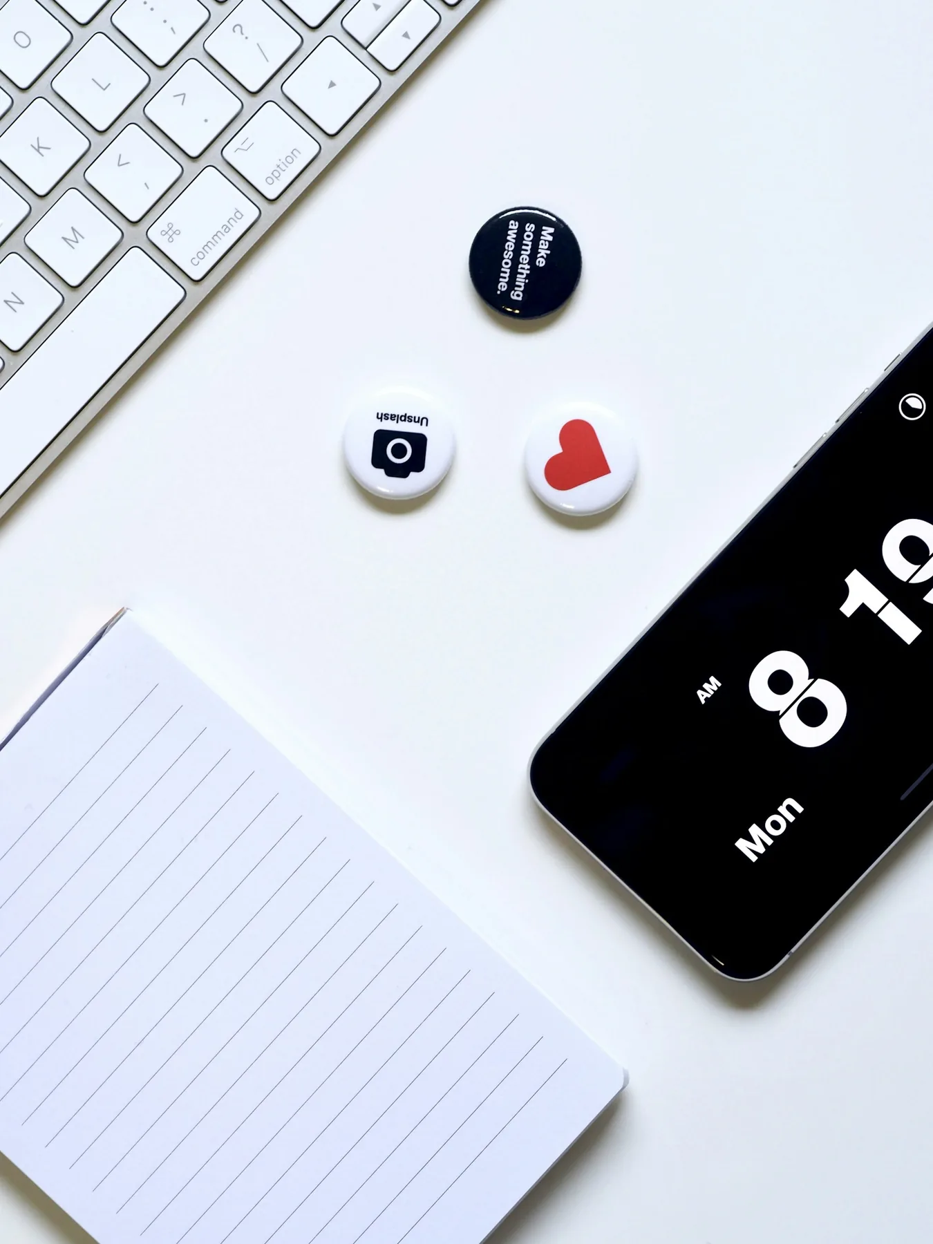 Teléfono, cuaderno y pequeños iconos de redes sobre una mesa