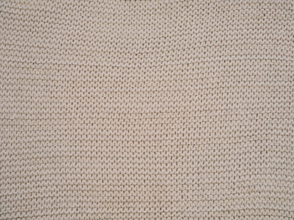 Primer plano de la trama de un tejido en tono beige