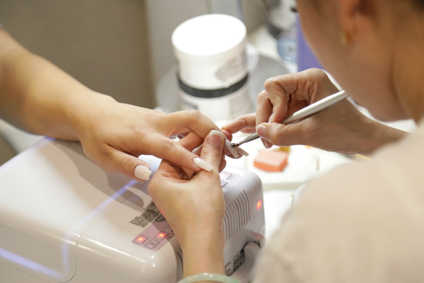 Primer plano de una profesional realizando una manicura a una clienta
